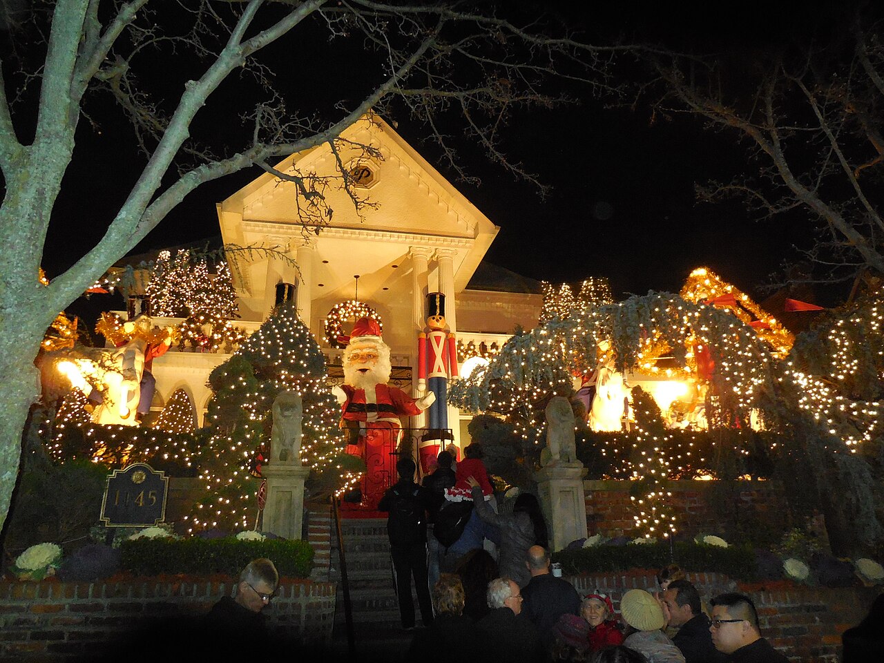 A house in Dyker Heights covered in Christmas lights with lit figures on the lawn