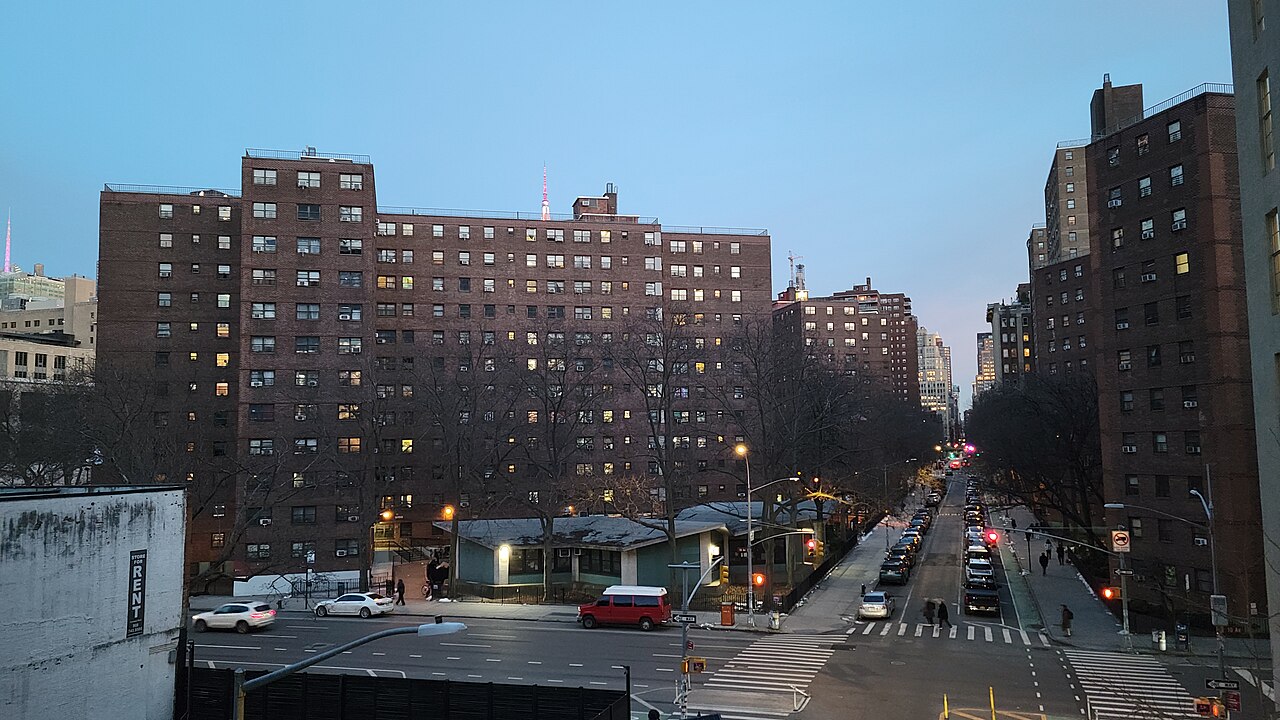 People walking along the High Line park above a Chelsea street, with planting beds beside the path